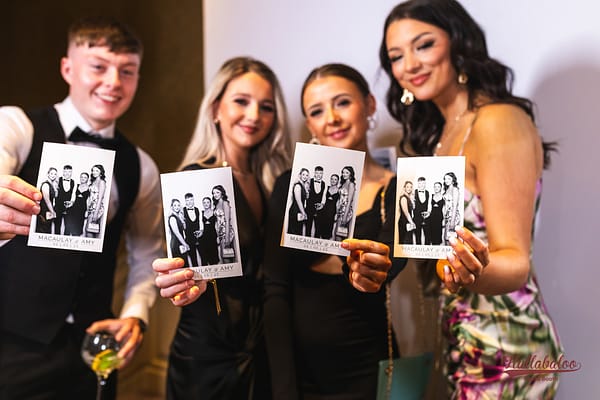 Guest at a wedding showing copies of their photos printed out